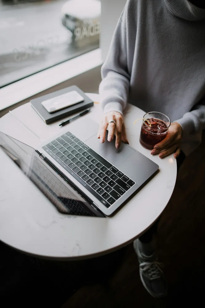 Empreendedora trabalhando em um notebook em uma cafeteria