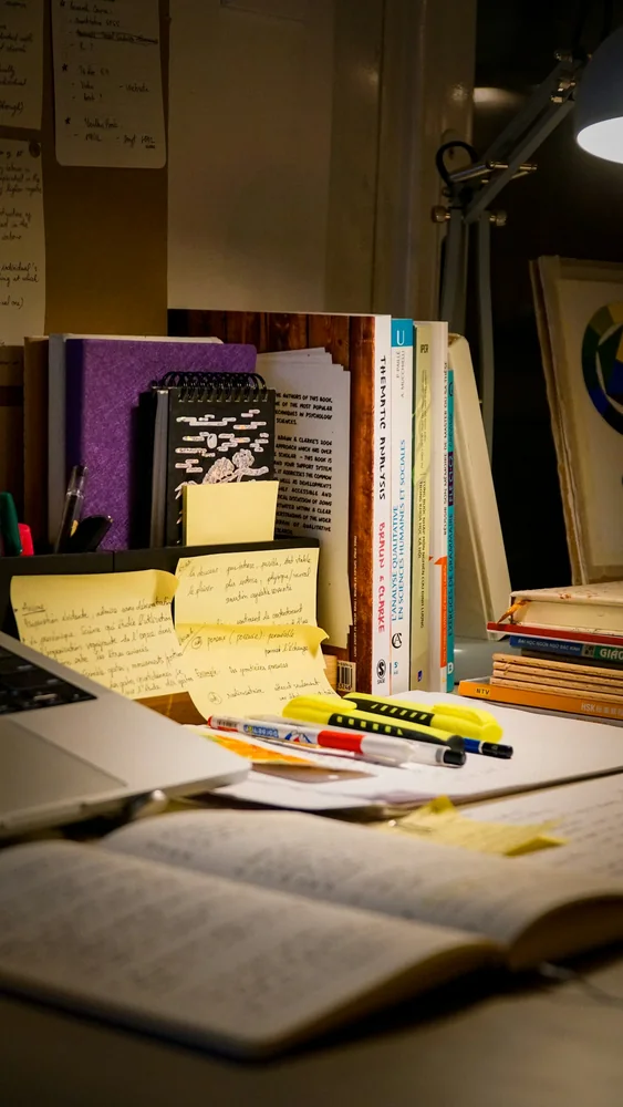 Mesa com laptop, livros e anotações durante o planejamento de um projeto
