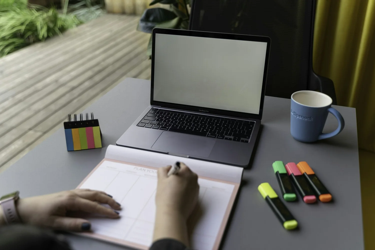 Pessoa planejando melhorias de um projeto com notebook e anotações